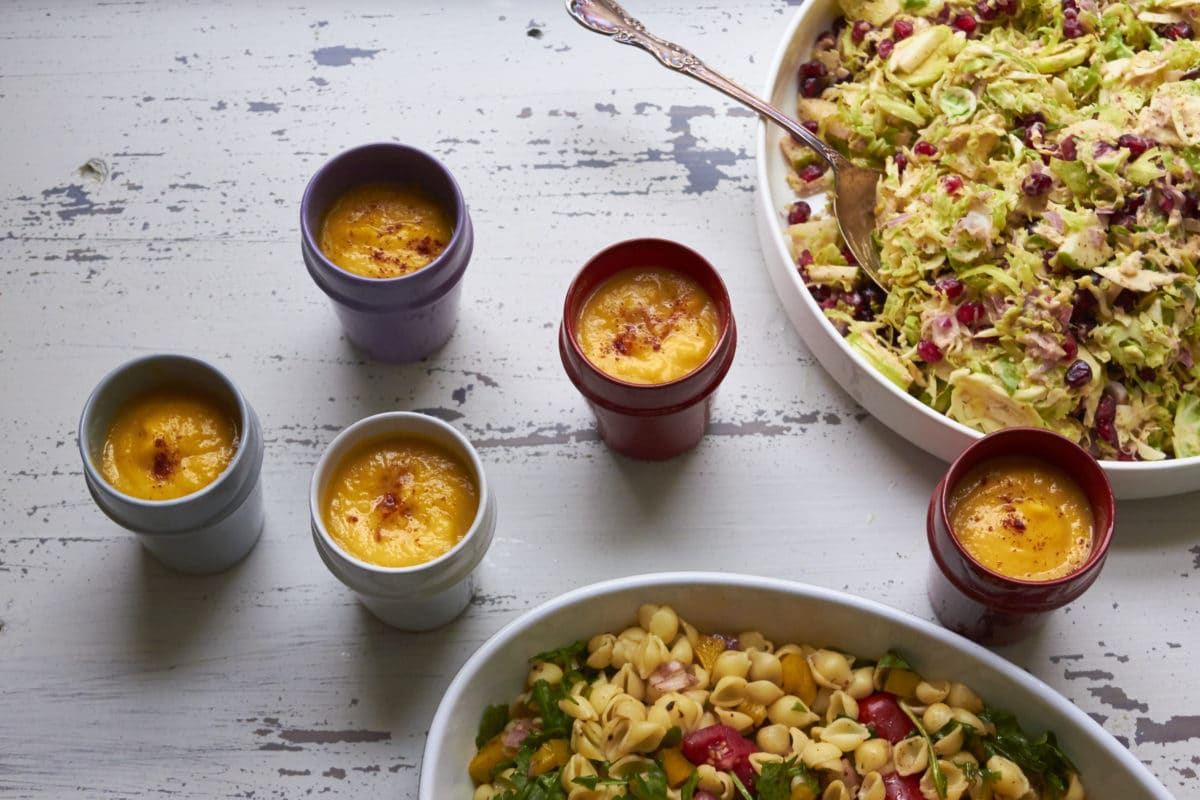 Cups of Butternut Squash and Fennel Soup next to bowls of salads.