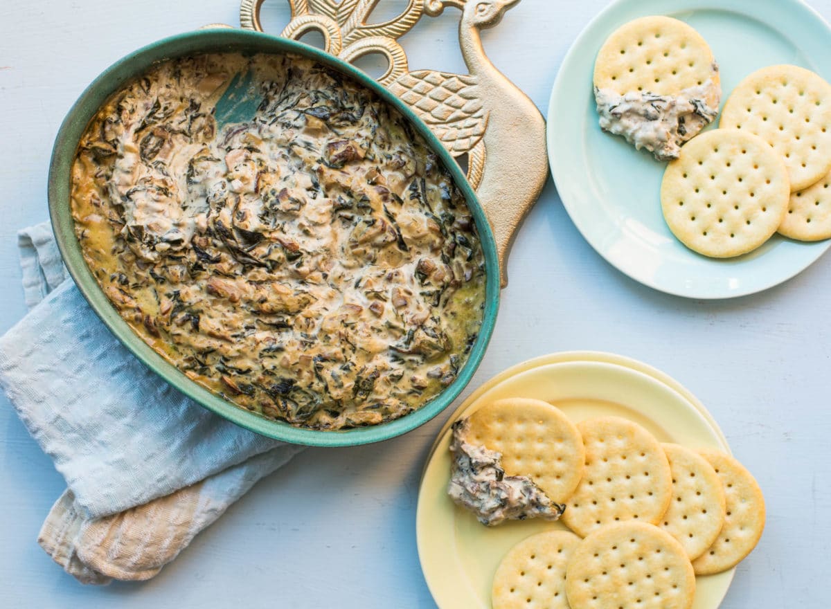 Hot Creamy Mushroom and Spinach Dip in a bowl and on crackers.