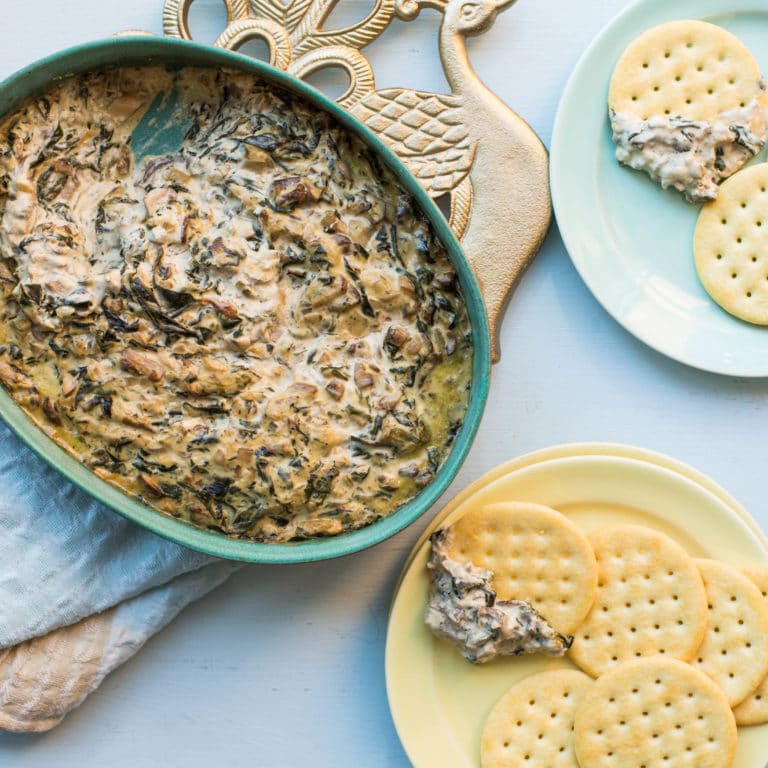 Hot Creamy Mushroom and Spinach Dip in a bowl and on crackers.