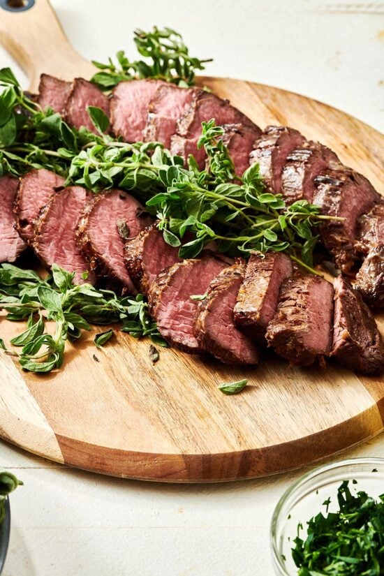 Sliced Marinated Petite Filets on a wooden surface.
