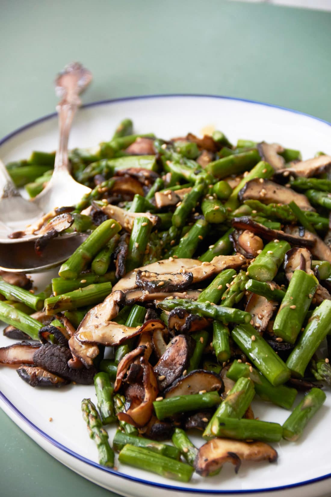 Serving dish piled high with Sesame Asparagus and Shiitake Mushrooms.
