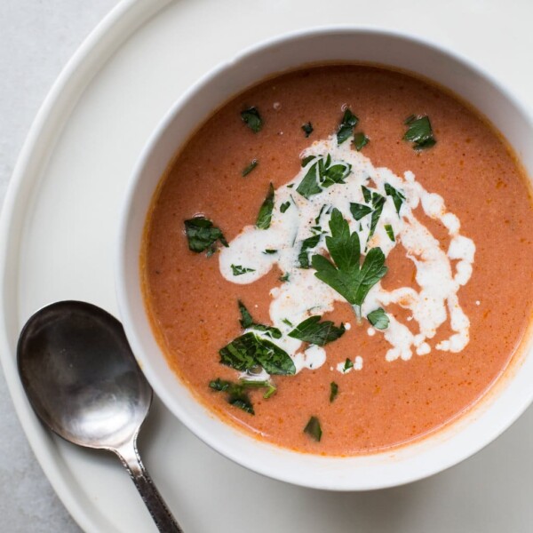 Creamy Tomato Soup in white bowl with spoon.
