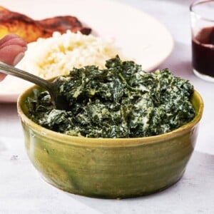 Creamed Kale and a fork in a green bowl.