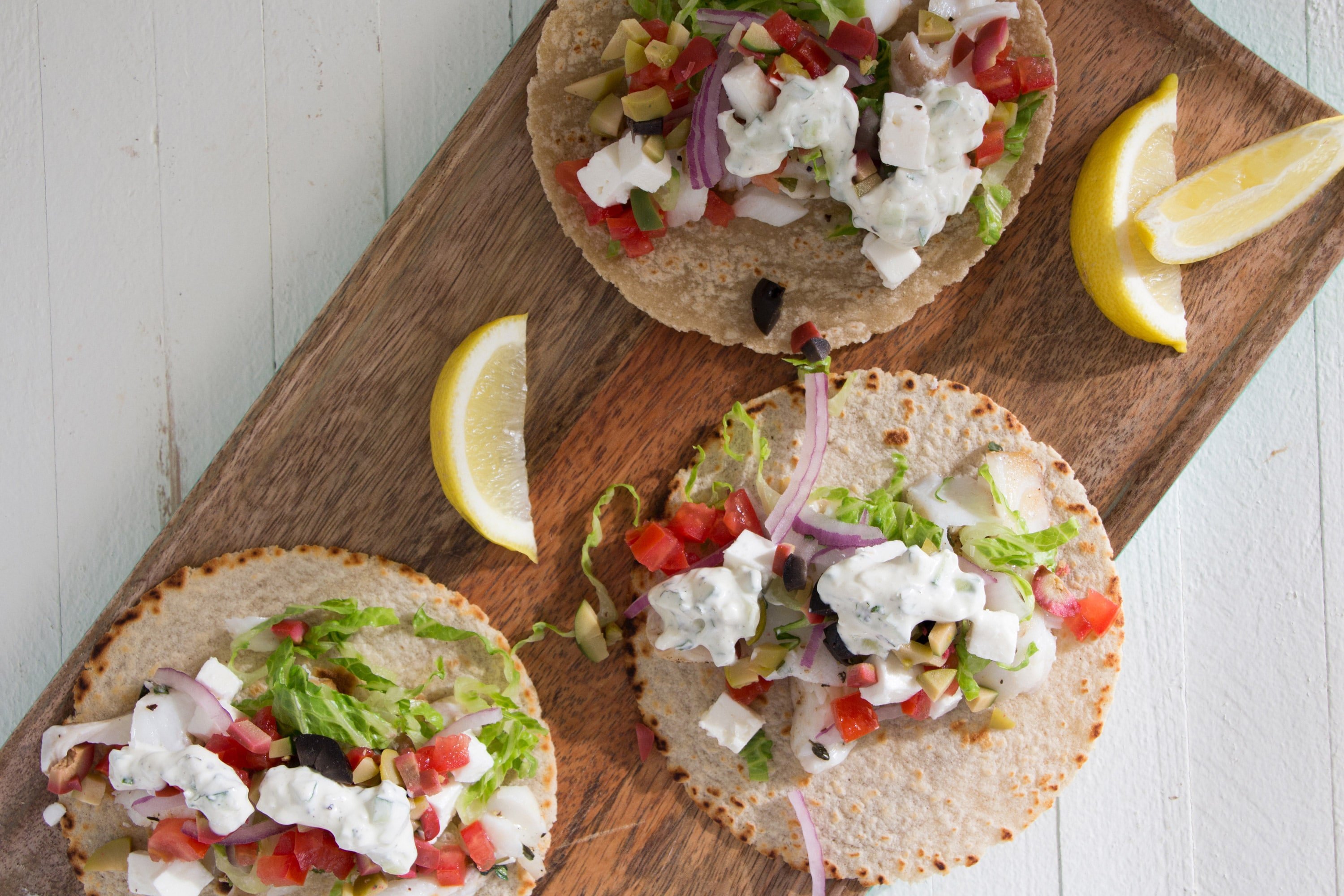 Greek Fish Tacos with perch, lettuce, olives, feta, and more.