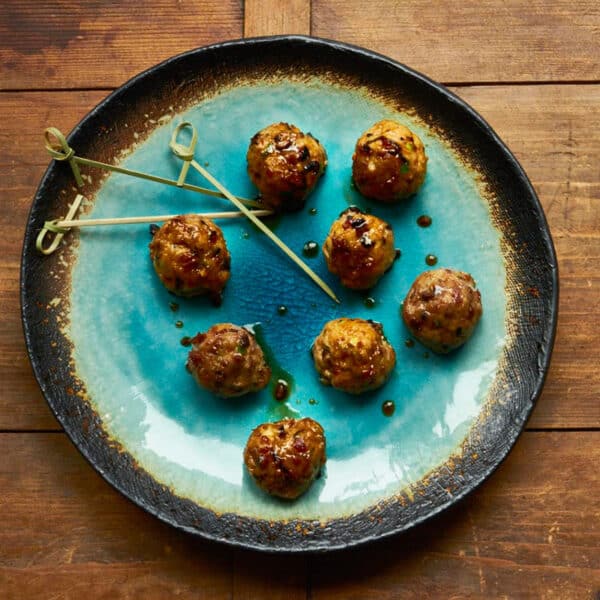 Plate of Japanese meatballs with glossy, sticky ponzu and soy sauce glaze.