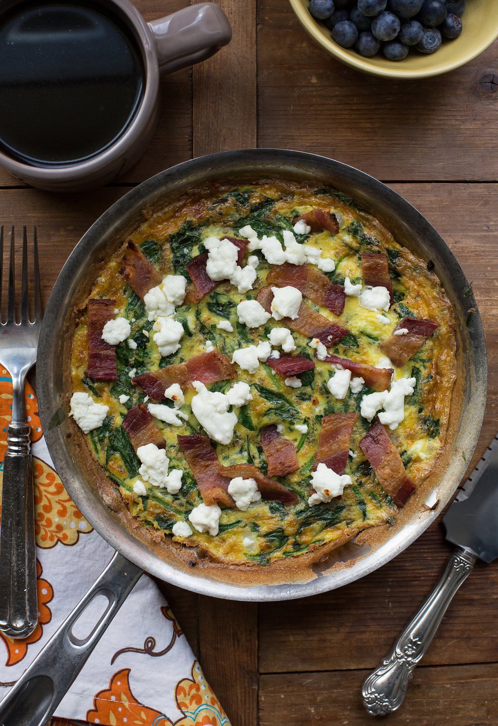 Lardons, Goat Cheese and Spinach Frittata in frying pan.