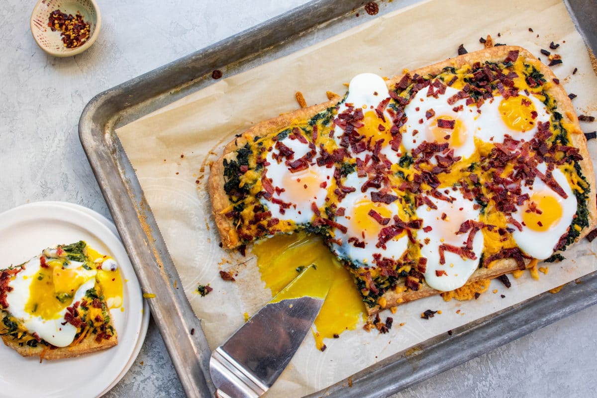 Puff Pastry Breakfast Tart with Spinach, Egg and Cheese on a lined baking sheet.