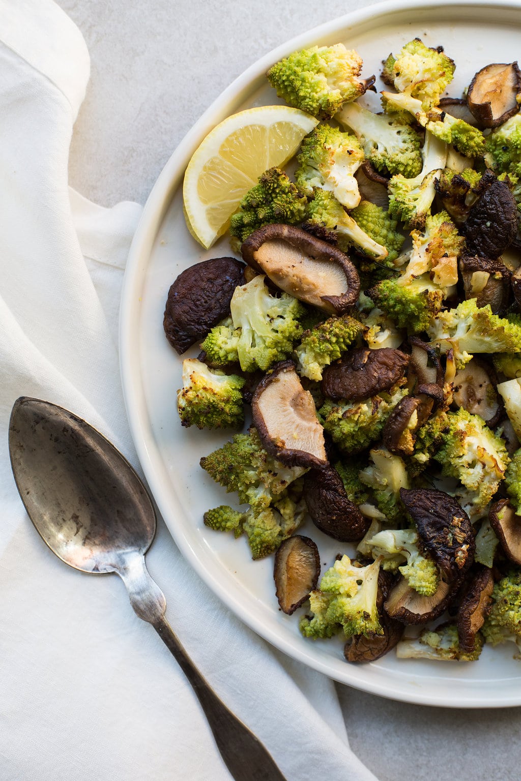 Roasted Broccoflower and Shiitake Mushrooms with Rosemary and Garlic on white plate.