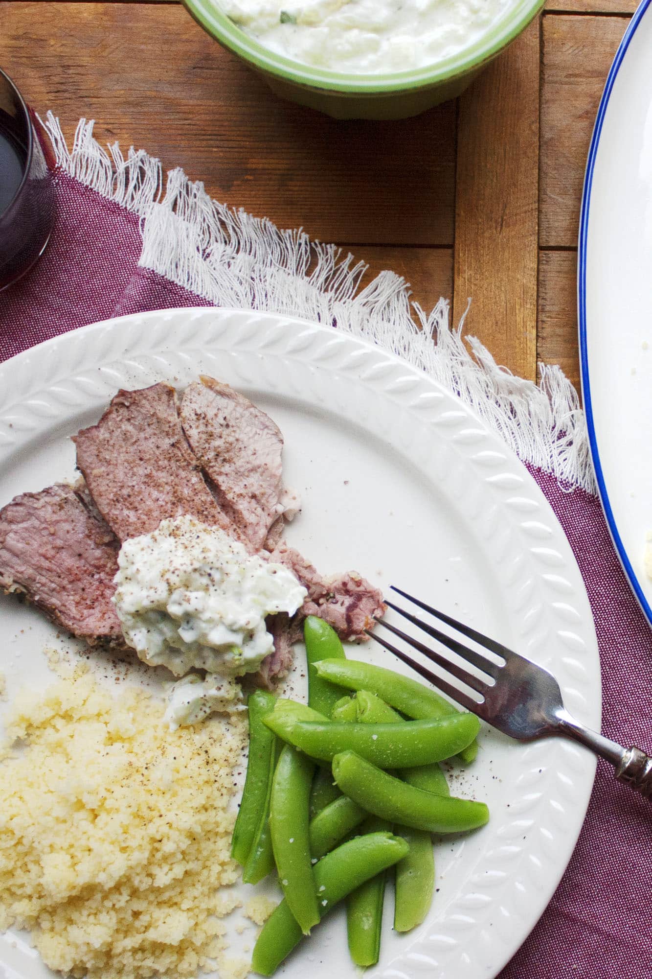 Slow Cooked Mediterranean Leg of Lamb with Tzatziki, couscous, and sugar snap peas.