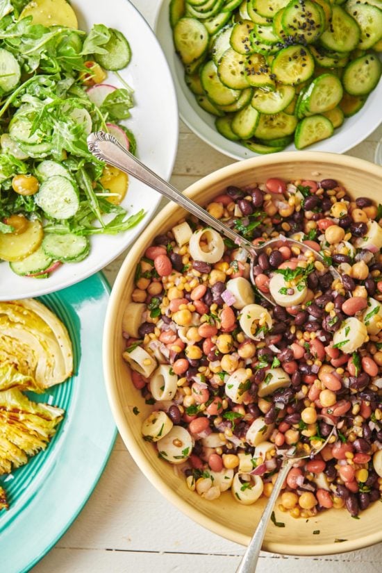 Modern Three Bean Salad on a table with other salads.