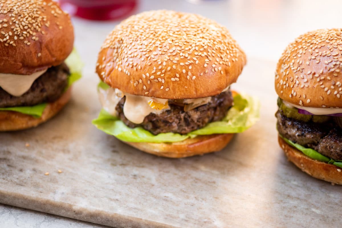 Line of Asian beef mushroom burgers on a marbled surface.
