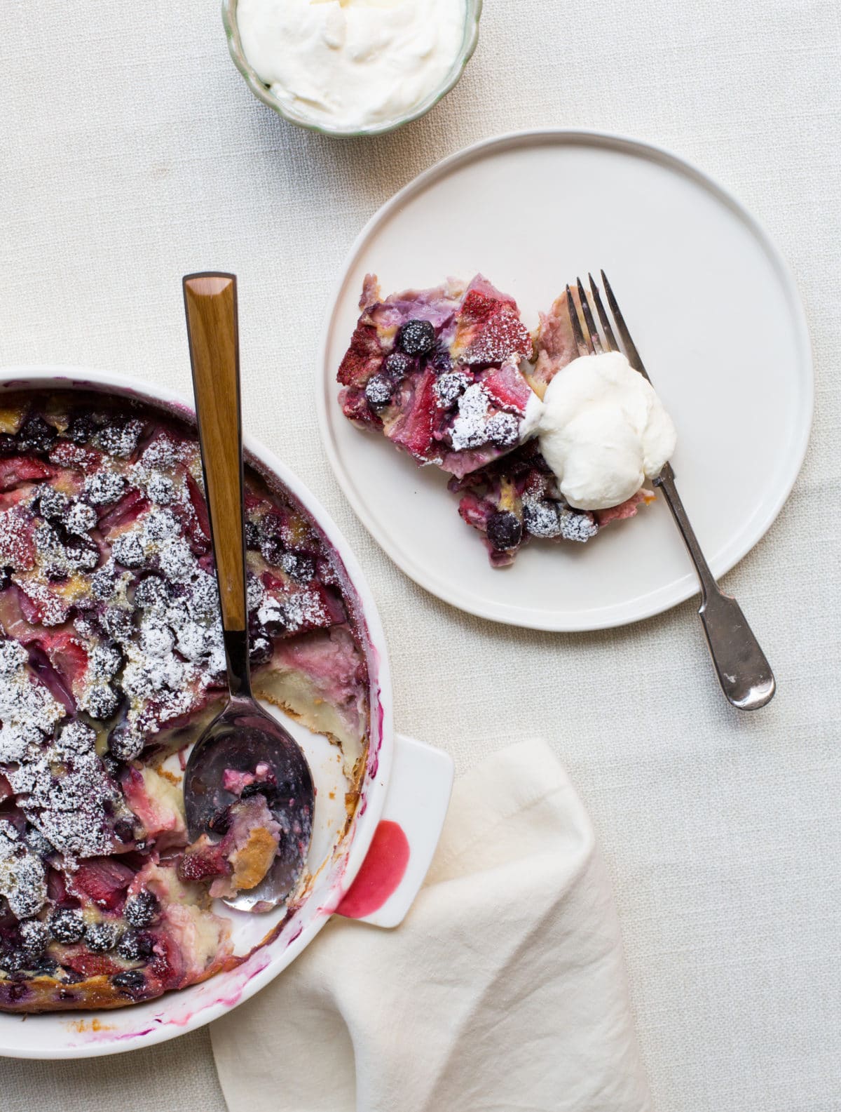 Plate with a piece of Summer Berry Clafoutis with Whipped Cream.