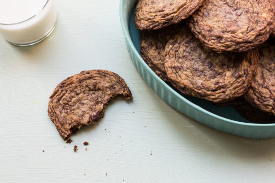 Half-eaten Fractaled Chocolate Chunk Cookie next to a bowl of cookies.