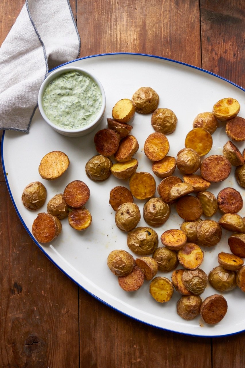 Roasted Potatoes with Arugula-Basil Dipping Sauce on white plate.