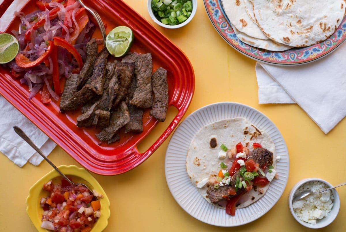 Steak Fajita on a plate surrounded by fajita ingredients.