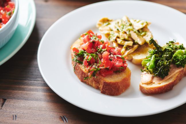 Tomato Bruschetta on a plate with other bruschetta.