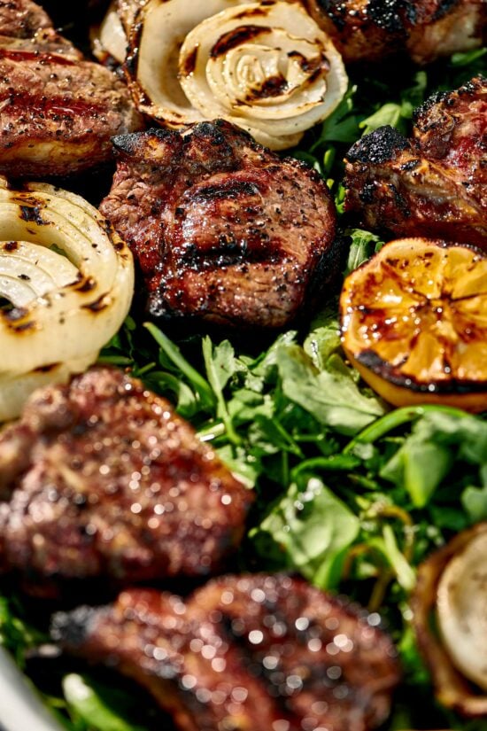 Grilled Lamb Chops, onions, and lemons over an herb salad.