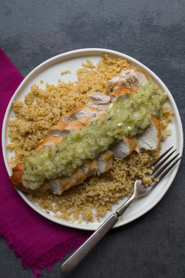 Fork on a plate of Pan-Seared Chicken Breasts with Roasted Tomatillo Salsa over couscous.