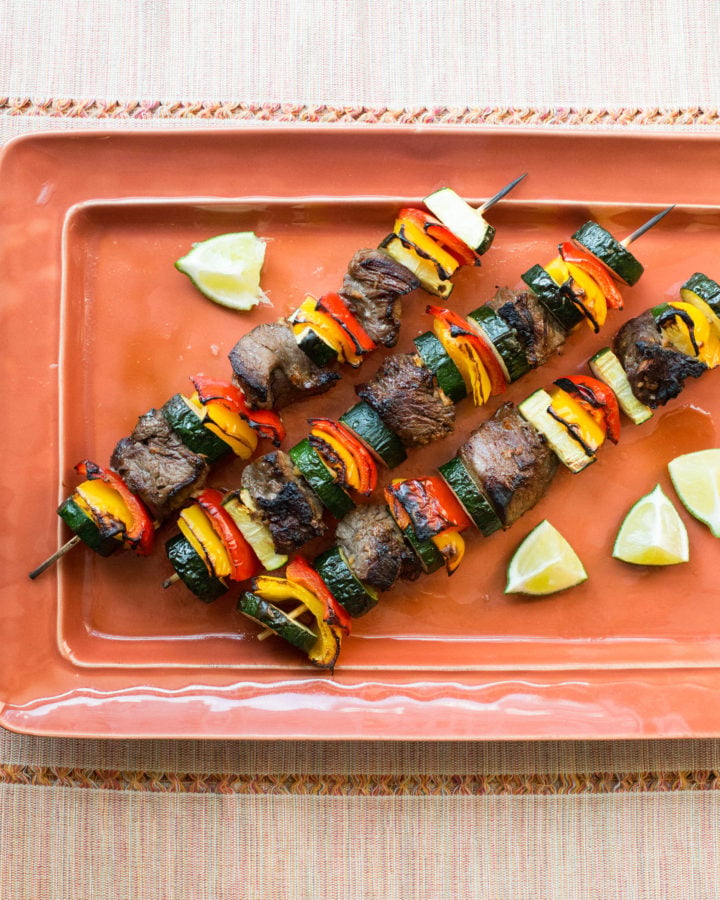 Rectangular tray of Beef Teriyaki Kebabs with Peppers and Zucchini.