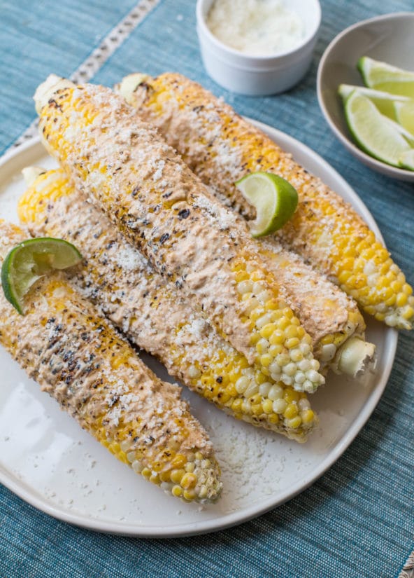 Elotes on a plate with limes