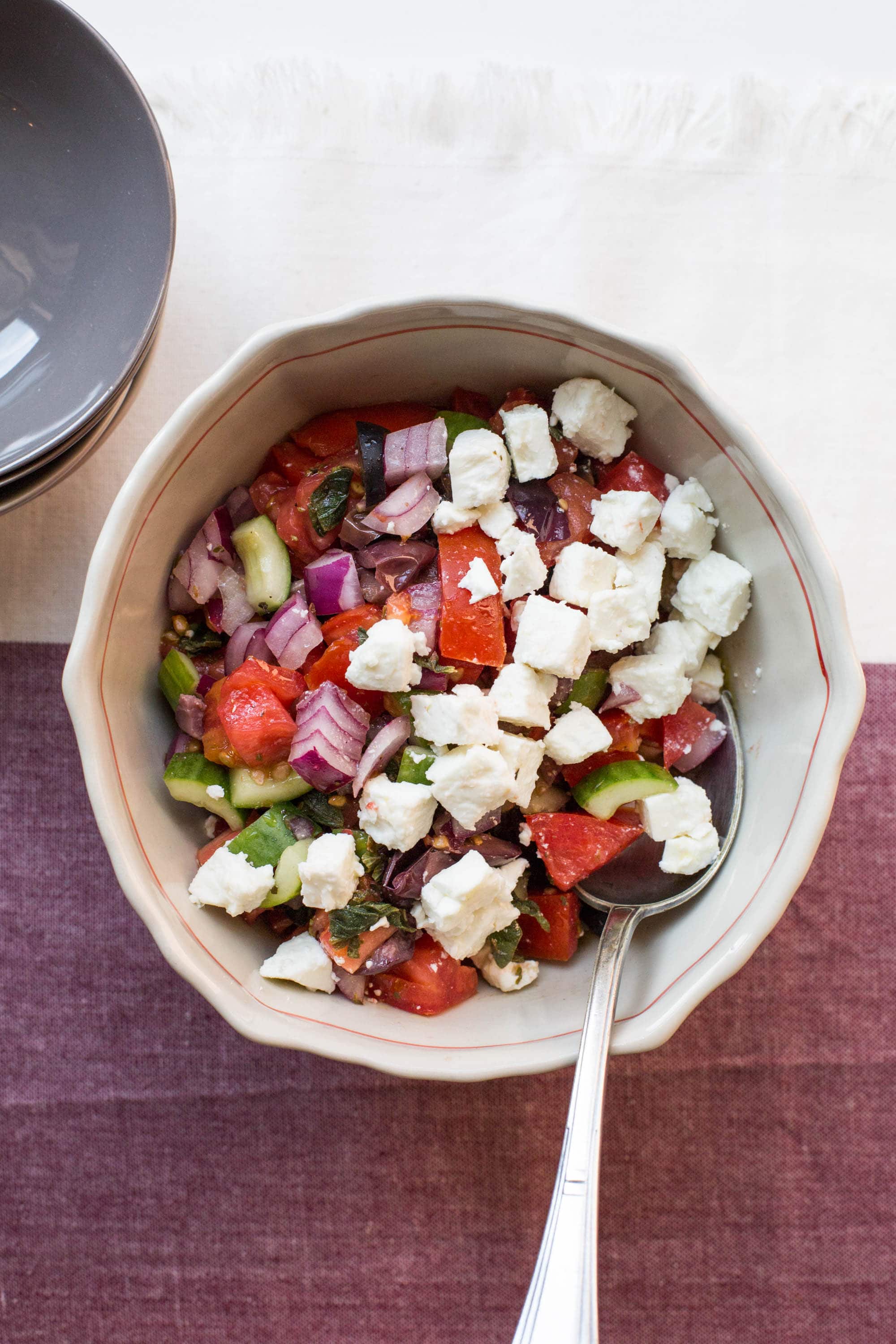Greek Tomato and Cucumber Salad in white bowl.
