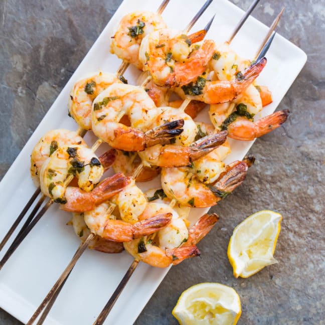 Several Citrus Basil Shrimp Kebabs piled on a plate.