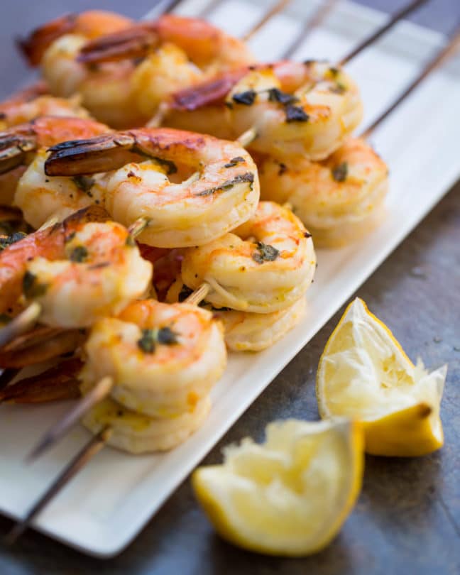 Lemon wedges next to Citrus Basil Shrimp Kebabs.