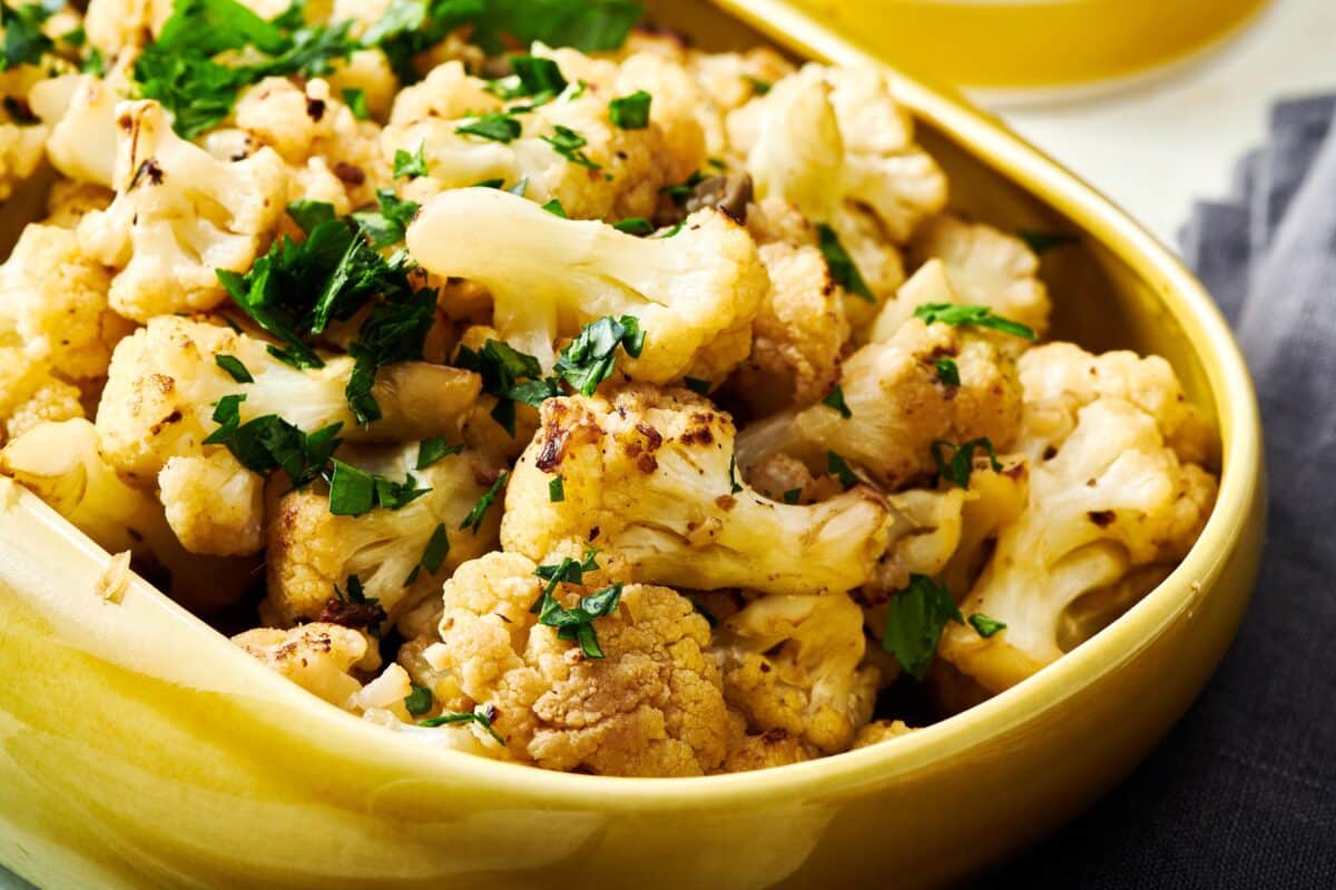 Bowl of Braised Cauliflower topped with parsley.