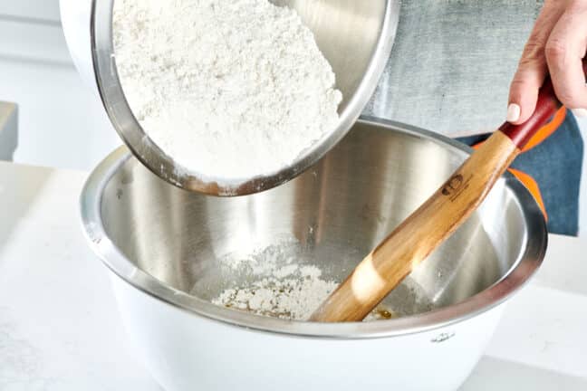 Flour being poured into a metal bowl.