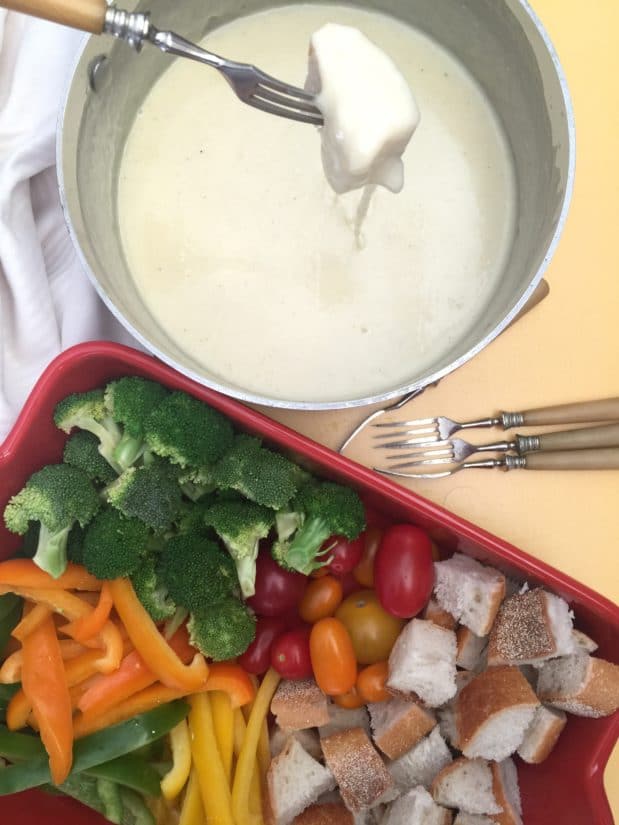 Tray of veggies next to a bowl of Classic Swiss Fondue.