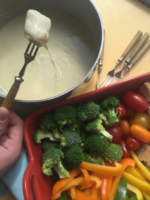 Tray of veggies next to a bowl of Classic Swiss Fondue with bread.