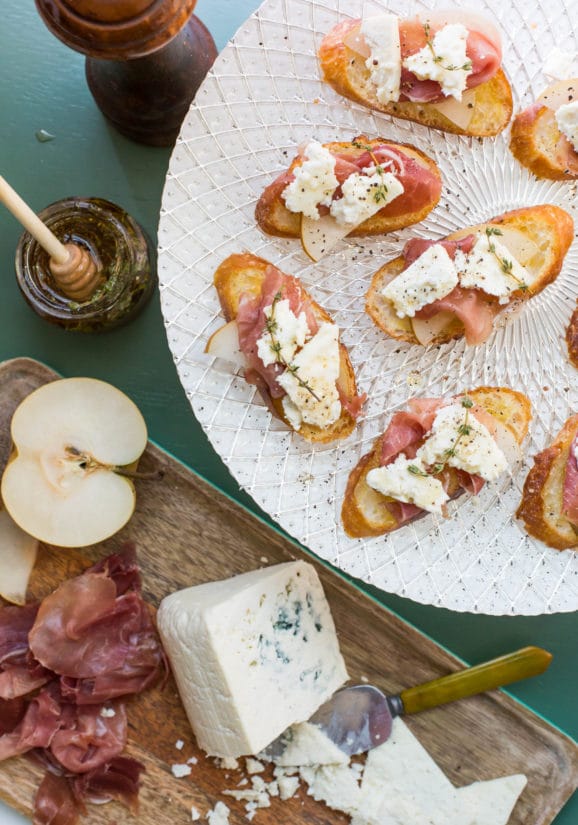 Prosciutto, Asian Pear and Blue Cheese Crostini on a white plate.