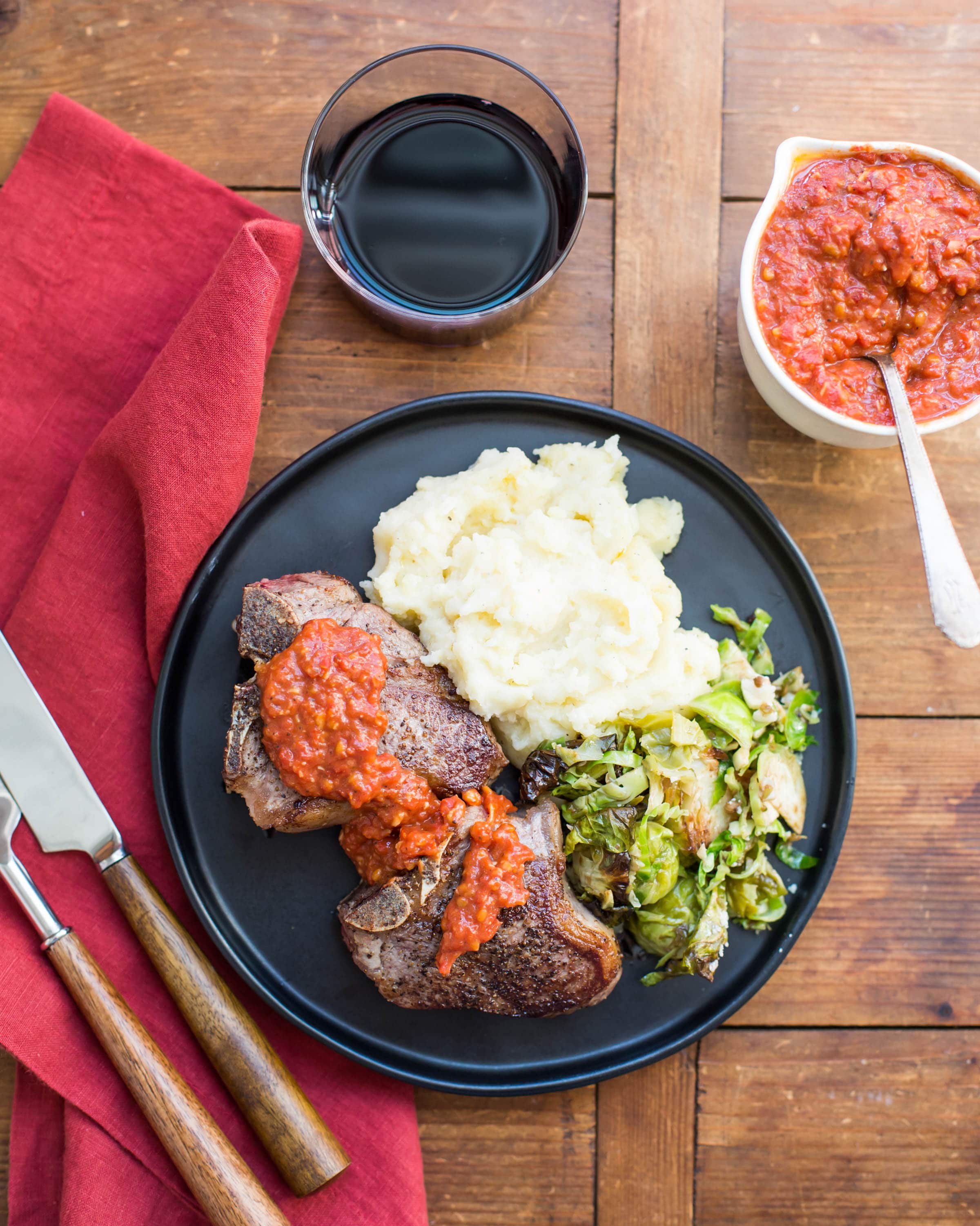 Loin Lamb Chops with Roasted Tomato and Garlic Sauce with mashed potatoes and brussels sprouts.