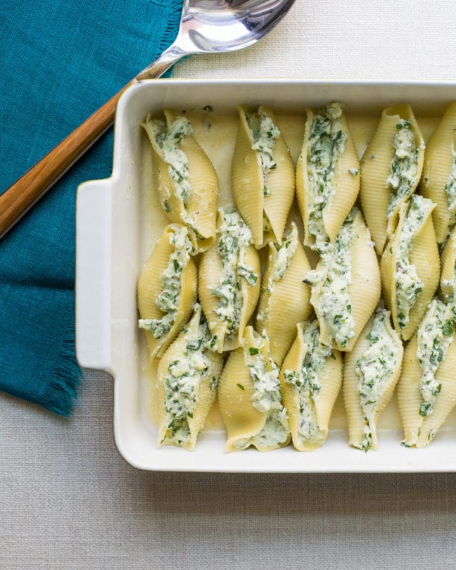 Baking dish of uncooked Spinach and Cheese Stuffed Shells.