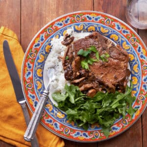 Pan-seared Pork Chops Marsala on colorful plate.