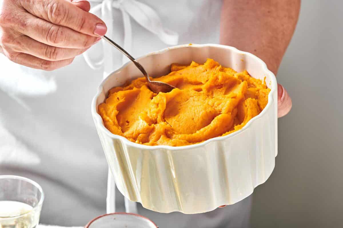 Serving bowl of Garlic Mashed Sweet Potatoes with spoon.