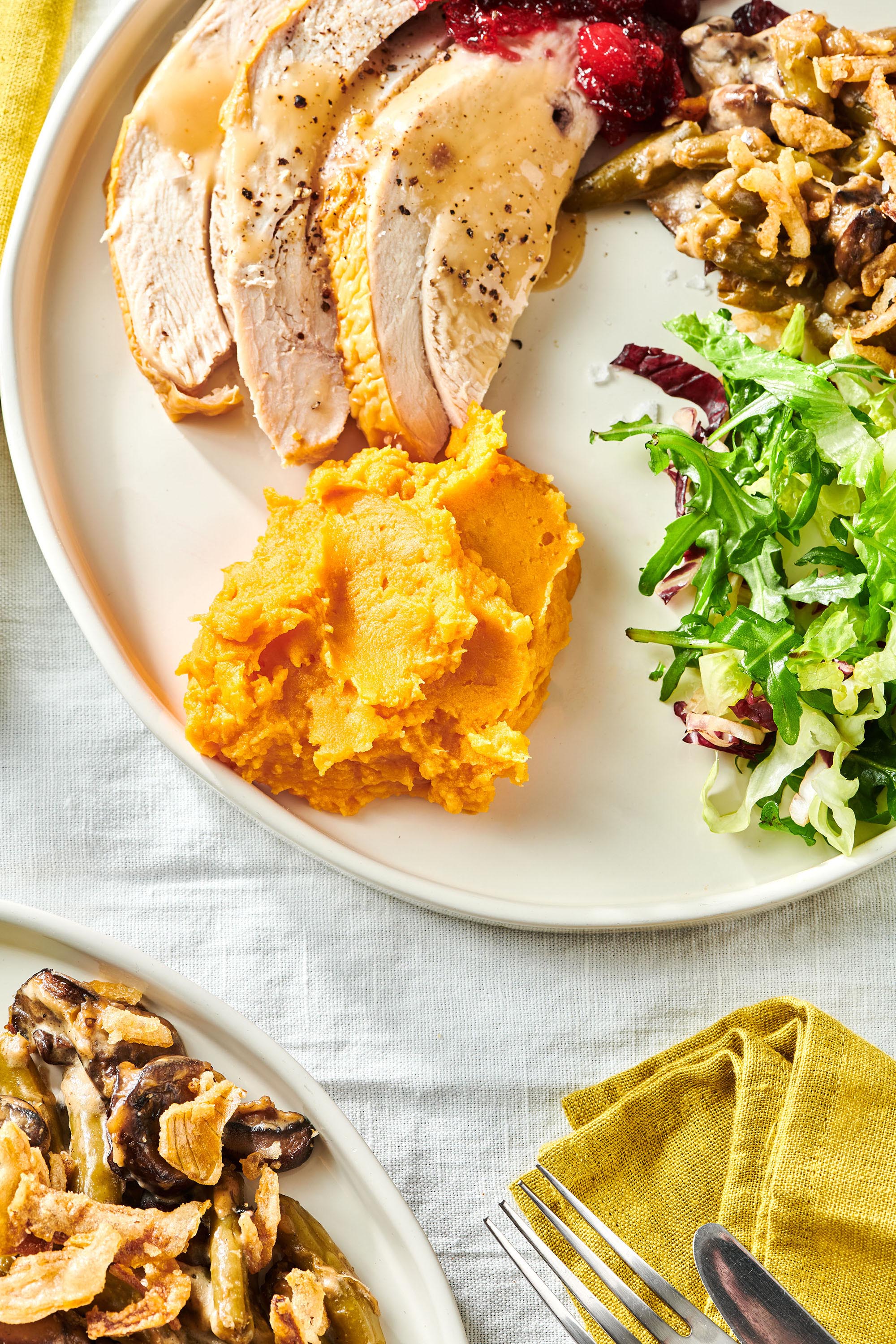 Plate of turkey, cranberry sauce, salad, and Garlic Mashed Sweet Potatoes.