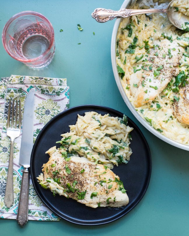 Black plate of Cheesy Chicken and Orzo.