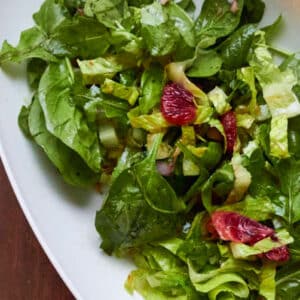 leafy green salad in bowl with pomegranate vinaigrette.