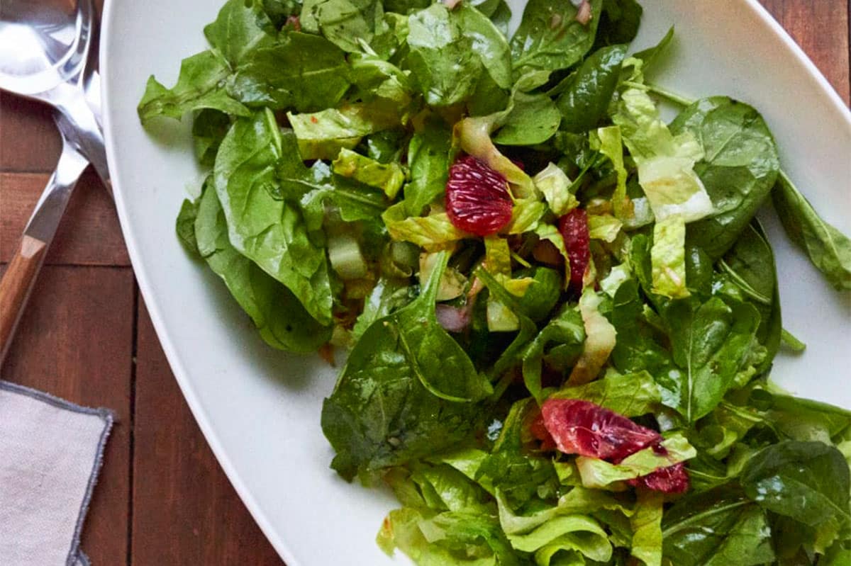 leafy green salad in bowl with pomegranate vinaigrette.