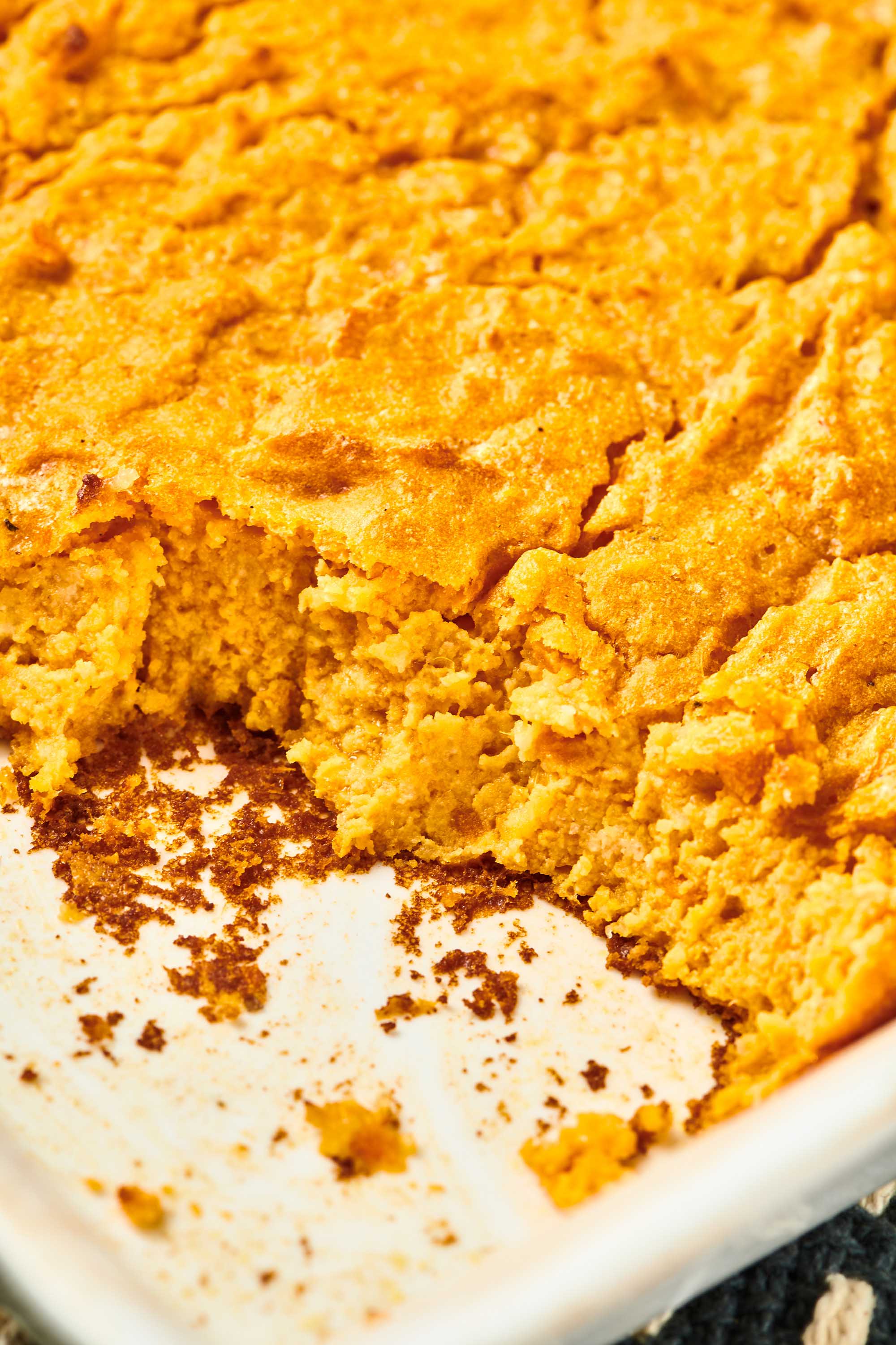 Sweet Potato Spoon Bread in a pan with a scoop removed.