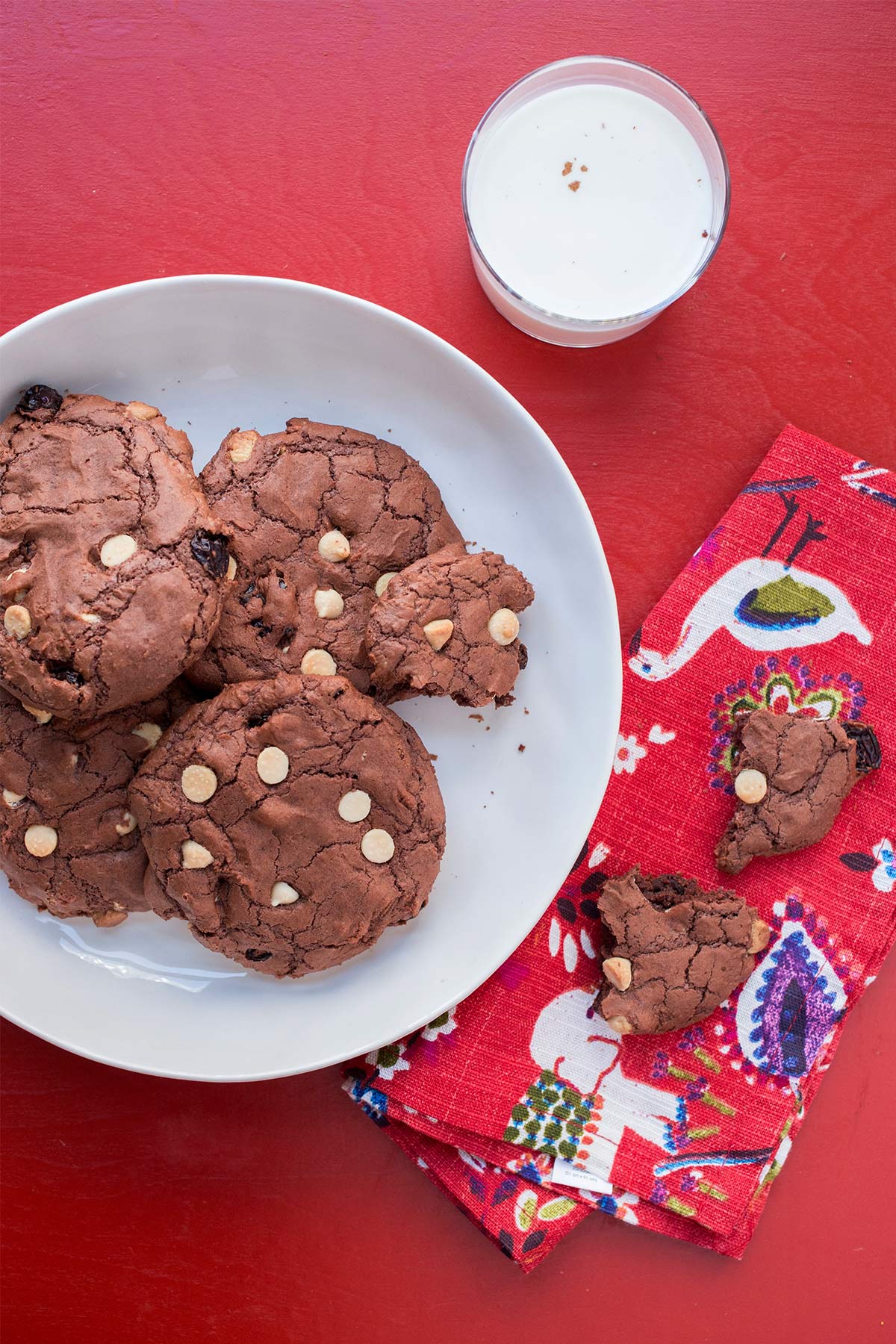 White plate and red napkin with Big Chewy Brownie Cookies with Dried Cherries and White Chocolate Chips.