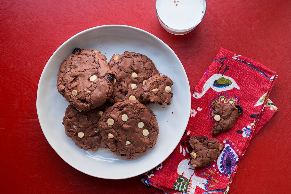 Big Chewy Brownie Cookies with Dried Cherries and White Chocolate Chips on a white plate.