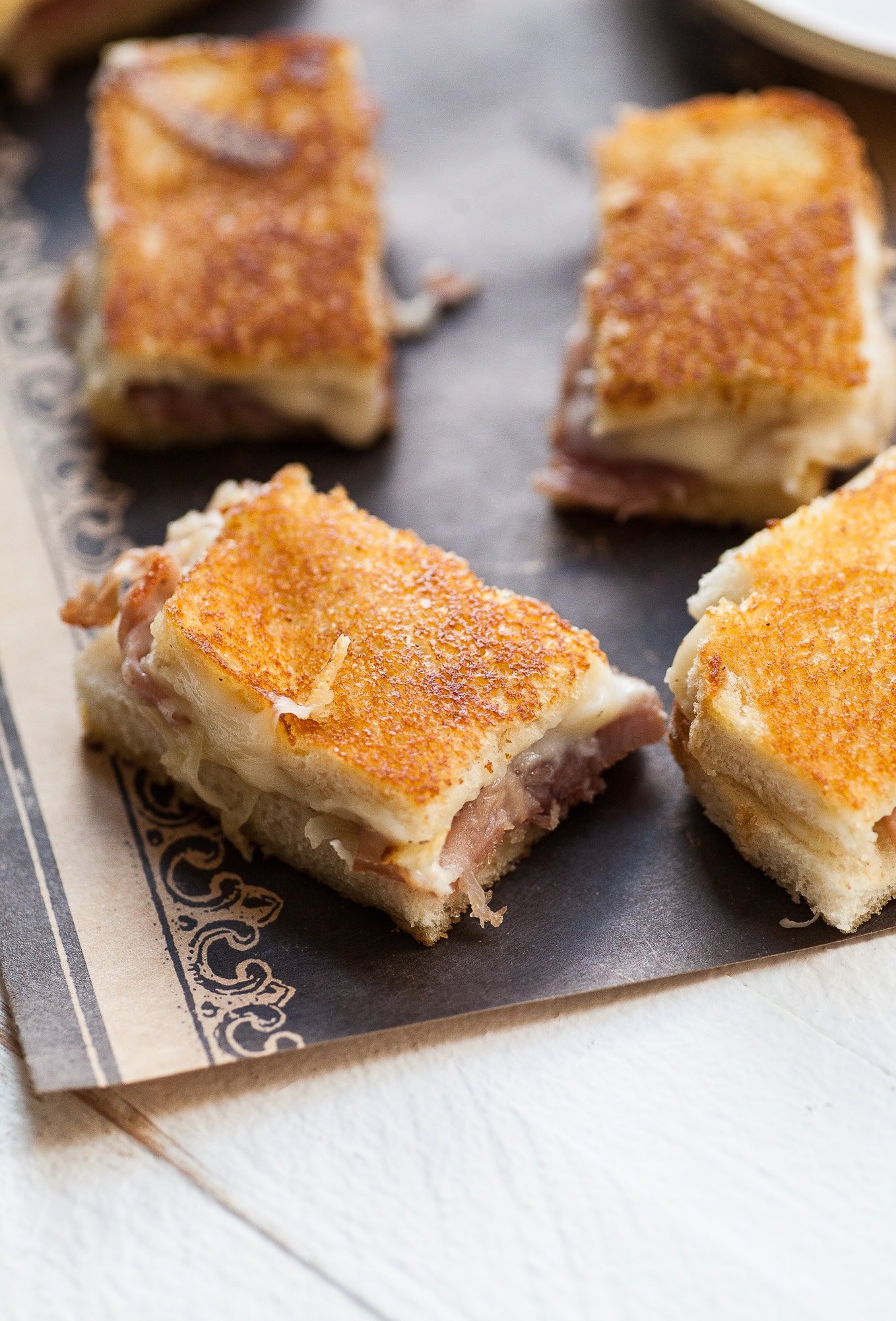 Mini Croque Monsieurs with Prosciutto on decorative paper.