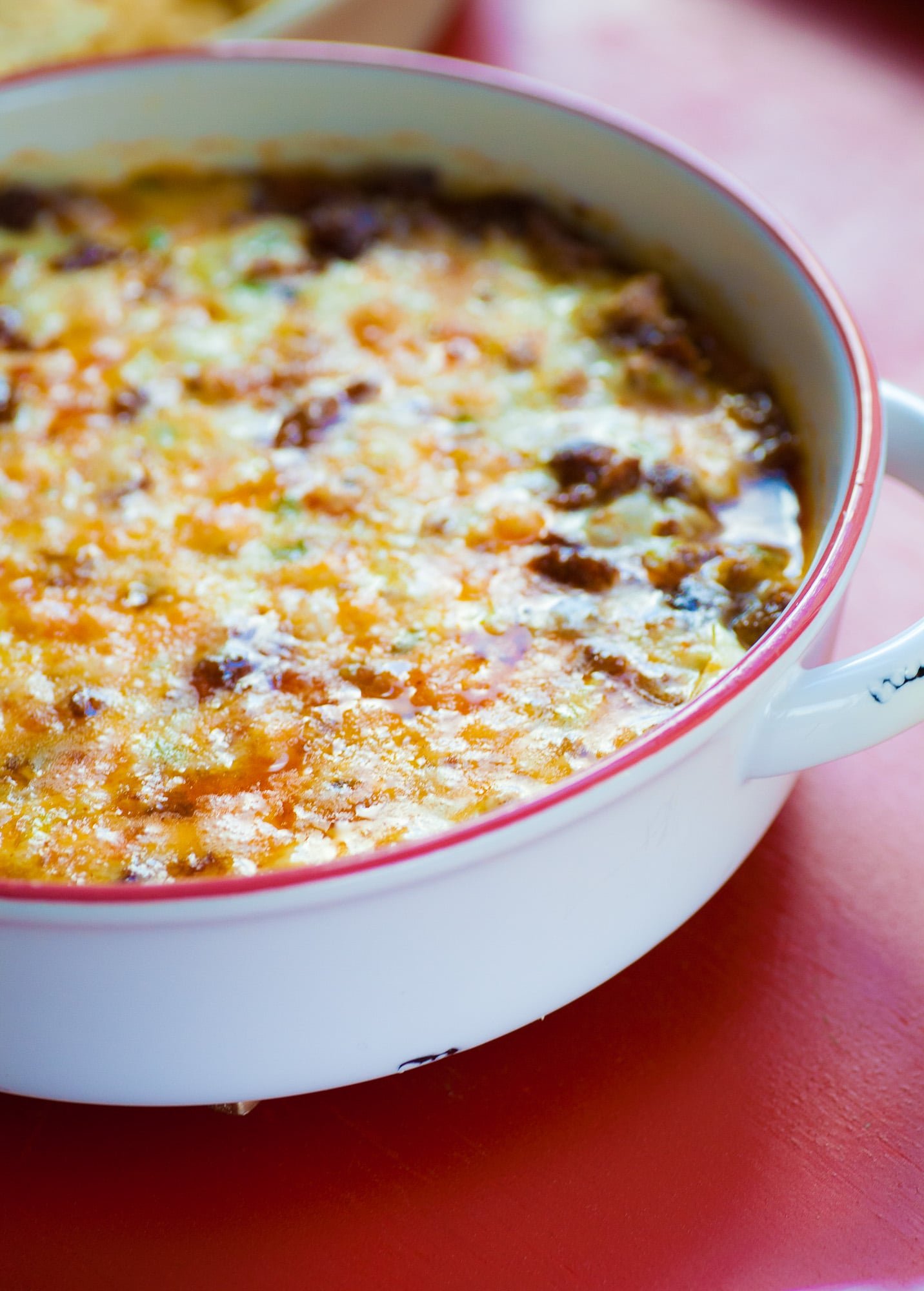 White, handled bowl of Queso Fundido with Chorizo.