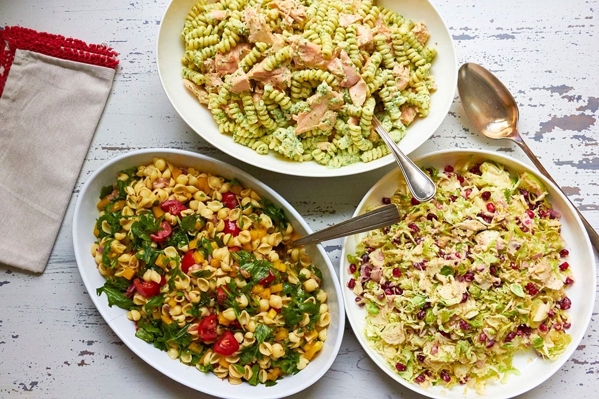 Bowl of Mayo-Free Vegan Pasta Salad on a table with other pasta salads.