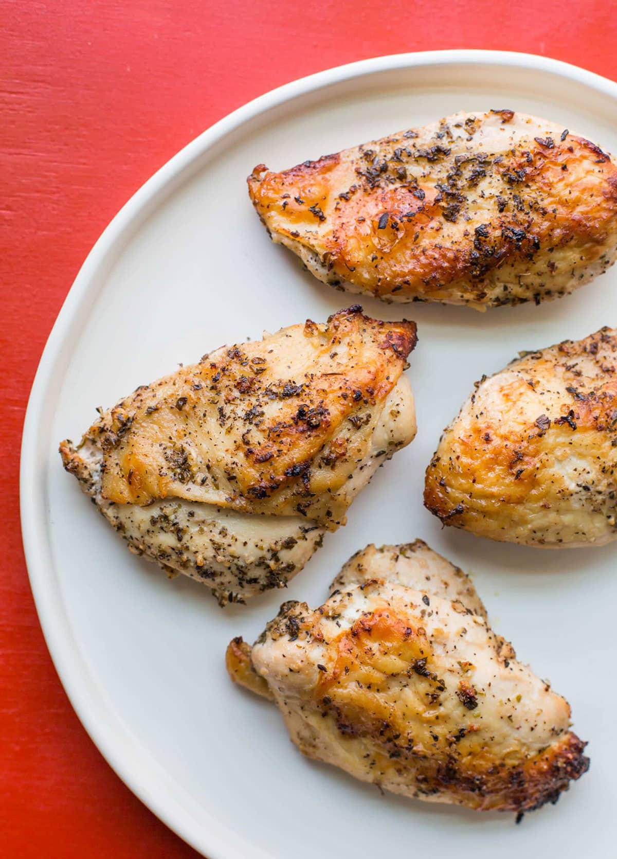 Greek Roasted Chicken Breasts on white plate.