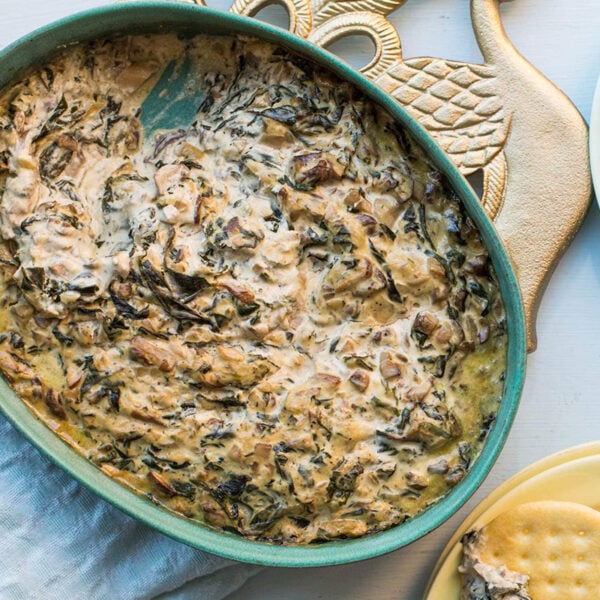 Hot Creamy Mushroom and Spinach Dip in a bowl and on crackers.