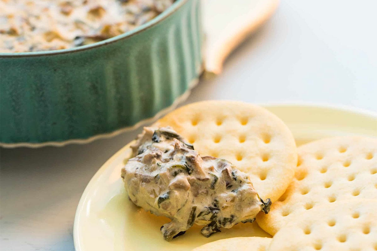 Hot Creamy Mushroom and Spinach Dip on a cracker.