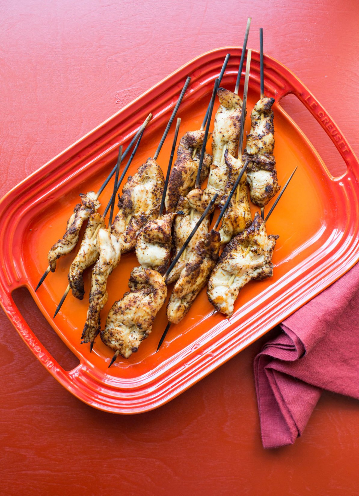 Orange Le Creuset platter of Chicken Tender Skewers with Spiced Curry Rub.